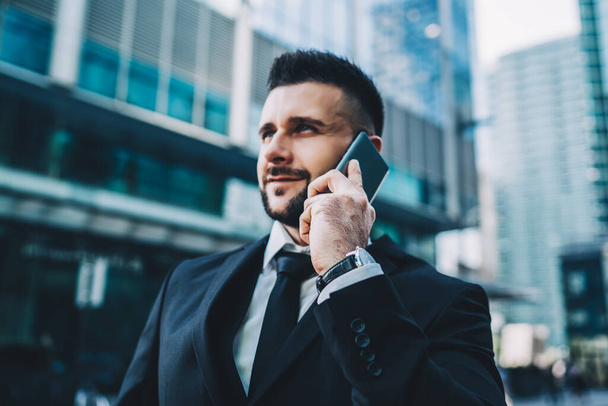 Special blurred filter of male entrepreneur communicating via cellphone gadget while standing outdoors, handsome Caucasian trader calling to enterprise colleague for discussing meeting place - Фото, зображення