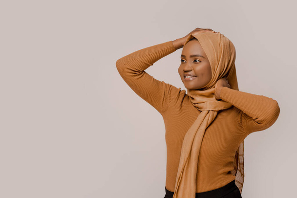 Muzułmanka piękna afrykańska narodowość nosząca tradycyjny hidżab, tradycyjny wschodni arabski islam ubrania religijne. Na białym tle studia. Ludzie i religia. Pewna siebie, mądra muzułmanka - Zdjęcie, obraz