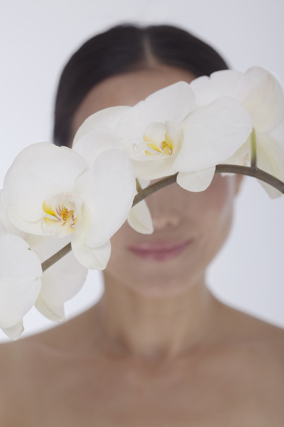 Frau hinter einem Bündel schöner weißer Orchidee - Foto, Bild