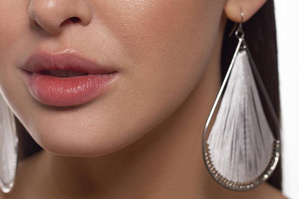 Sexual full lips. Natural gloss of lips and woman's skin. The mouth is closed. Increase in lips, cosmetology. Orange lips and long neck. Great summer mood with open eyes. fashion jewelry - Foto, imagen