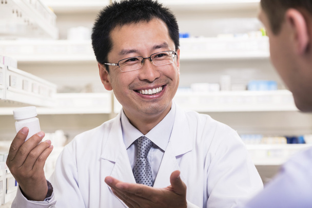 Фармацевт показывает рецептурные лекарства клиенту
 - Фото, изображение