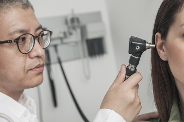 Medico che controlla le orecchie di un paziente
 - Foto, immagini