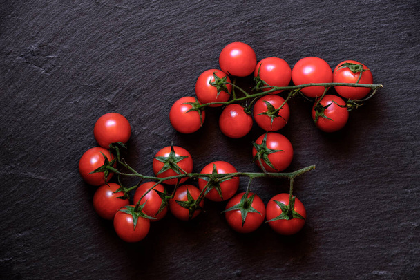 Siyah arka planda taze kiraz domatesleri. Üst görünüm - Fotoğraf, Görsel