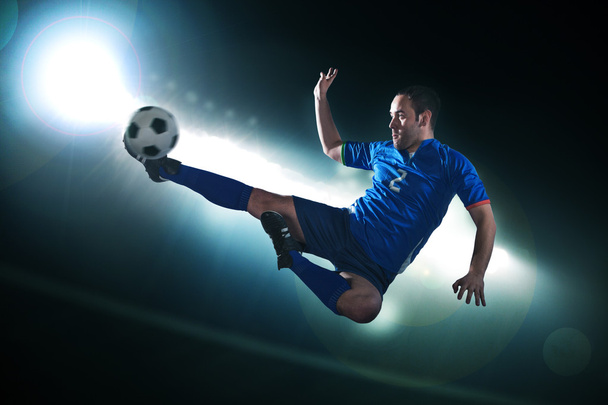 Soccer player in mid air kicking the soccer ball - Photo, Image