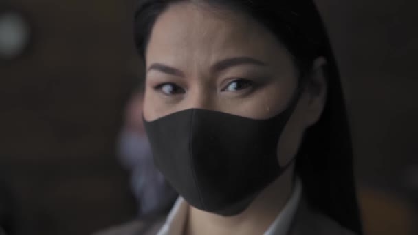 Asian businesswoman looking at the camera wearing pollution mask.  - Metraje, vídeo