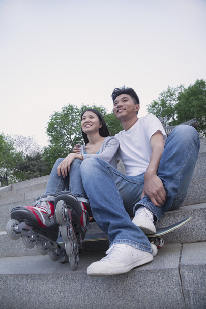 Couple with a skateboard and roller blades - Photo, Image