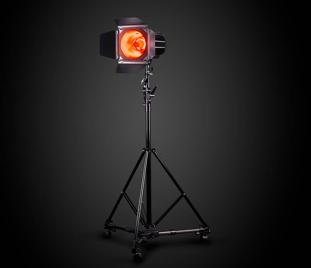 Photography studio flash on a lighting stand isolated on black background with lamp. Proffetional equipment like monobloc or monolight - Photo, Image
