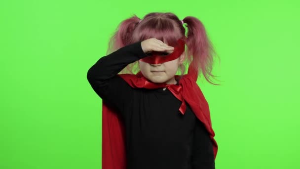 Lustiges Kindermädchen in Kostüm und Maske spielt Superheldin. Nationaler Superheldentag - Filmmaterial, Video