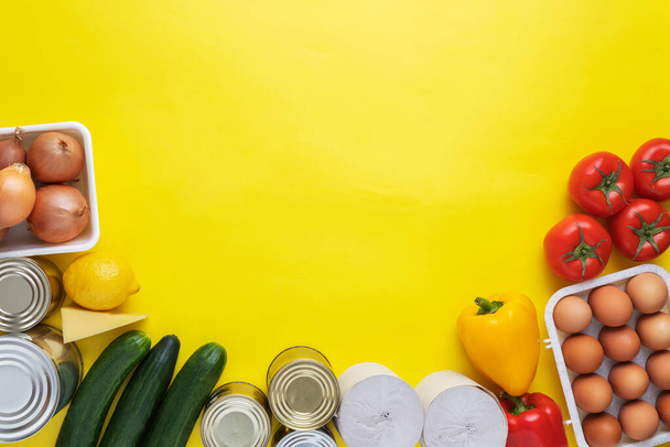 Food donations on yellow background. Food help . Top view with copy space - Photo, Image