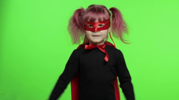 Lustiges Kindermädchen in Kostüm und Maske spielt Superheldin. Nationaler Superheldentag - Filmmaterial, Video