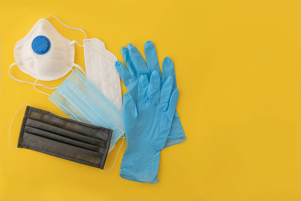 Medical masks. Yellow background. Face mask protection against pollution, virus, flu and coronavirus. Pair of latex medical gloves. Health care concept. - Photo, Image