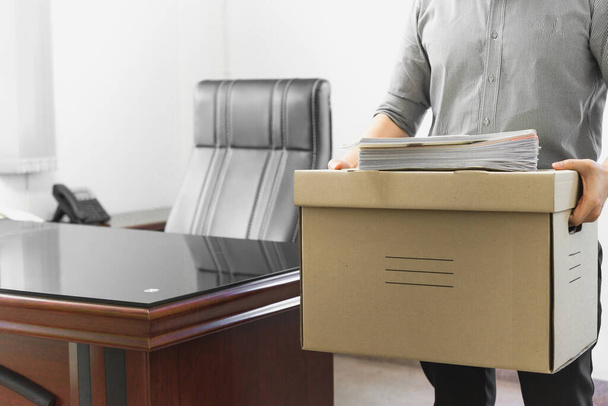 Upset employee packing belongings in box, frustrated stressed man getting fired from job ready to leave on last day at work, sad office worker - Photo, Image