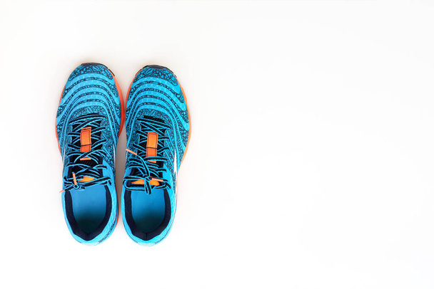 Concept lancé. Concept love run. Paire de chaussures de course bleu tendance pour hommes sur fond blanc. Vue du dessus
. - Photo, image
