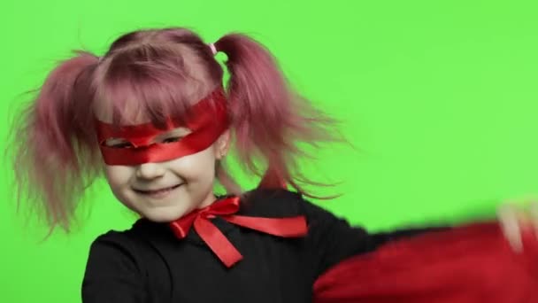 Funny niña en traje y máscara juega super héroe. Día nacional del superhéroe
 - Imágenes, Vídeo