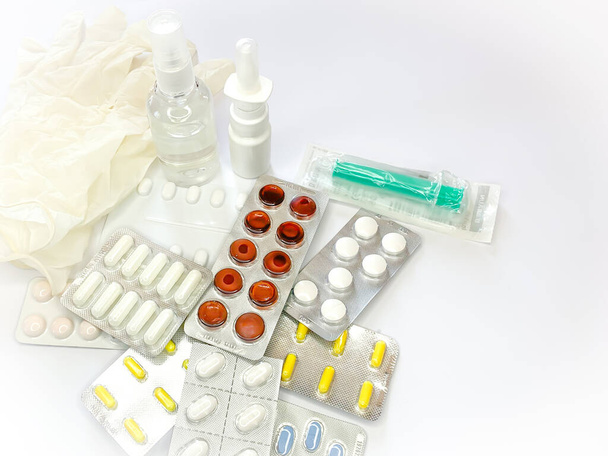 Different medicines: tablets, pills in blister pack, medications drugs, medical gloves, mask, syringe, spray, sanitizer. Close up, space for text. Horizontal image - Фото, зображення
