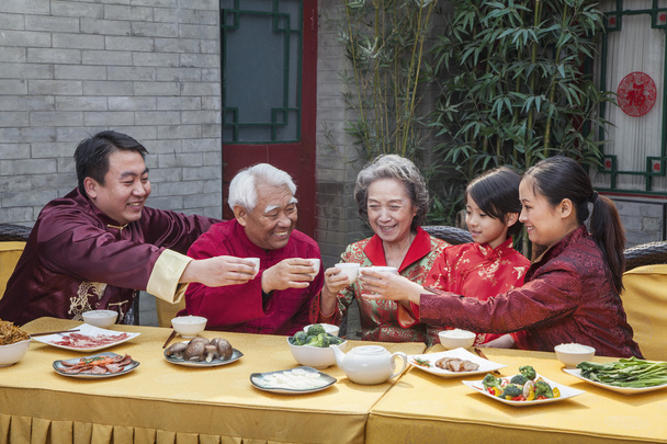 Сім'я кубками підняв тостів над китайської їжі - Фото, зображення