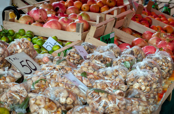 Paquets de figue séchée et grenade mûre dans des boîtes en bois sur un comptoir de marché agricole
 - Photo, image