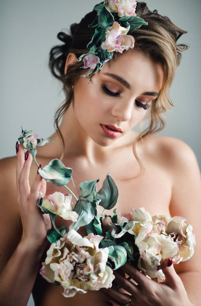 Beautiful woman covers the body with flowers Creative handmade flowers made of genuine leather and silk. Close-up portrait. - Φωτογραφία, εικόνα