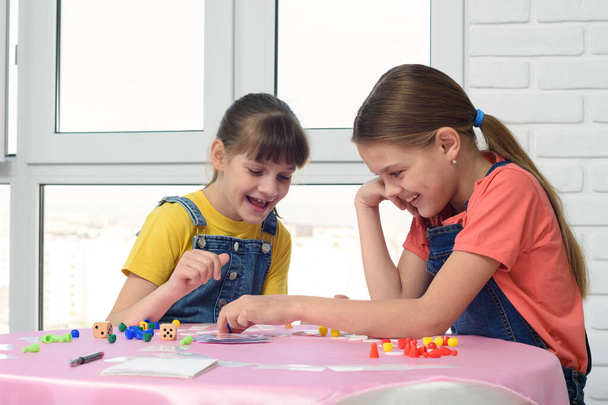 Δύο κορίτσια διασκεδάζουν παίζοντας επιτραπέζιο παιχνίδι - Φωτογραφία, εικόνα