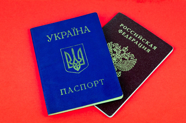 Kaksi kansallista sisäistä passia, punainen Venäjän passi ja sininen Ukrainan passi punaisella taustalla
 - Valokuva, kuva