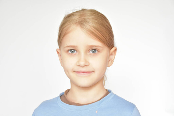 Retrato de uma menina loira em um fundo branco
 - Foto, Imagem