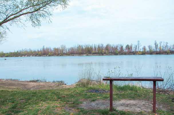Ławka samotna po stronie rzeki - Zdjęcie, obraz