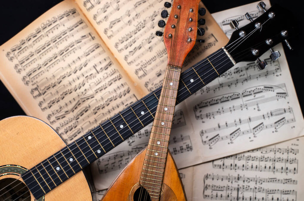 Mandolin e guitarra com velhos livros de partituras borradas no fundo
.   - Foto, Imagem