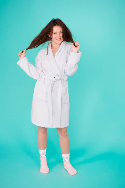 Girl no makeup face long hair wear bathrobe turquoise background. Ready for spa procedures. Woman relaxed after massage session or spa. Beauty salon. Spa and skin care. Spa and wellness concept - Foto, Imagem