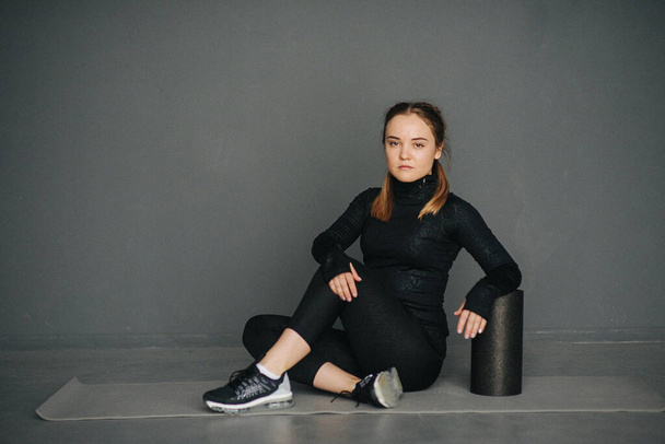 Caucasian female sportswoman uses a foam roller for relaxation, stretching muscles and back pain in workout in pilates studio. Set photo with film photo gain. - Photo, Image