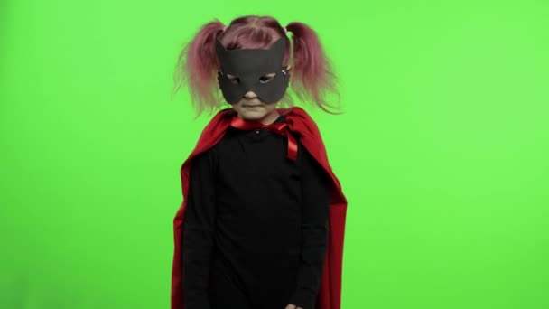 Funny niña en traje y máscara juega super héroe. Día nacional del superhéroe
 - Imágenes, Vídeo