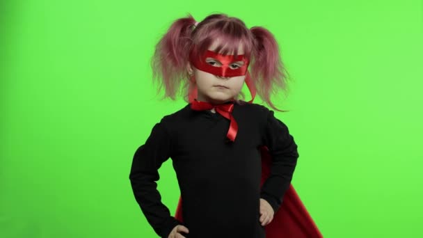Grappig kind meisje in kostuum en masker speelt super held. Nationale superheldendag - Video
