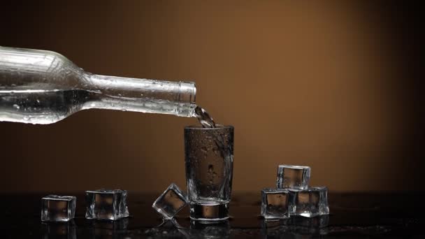 Pouring up shot of vodka into glass. Dark brown background. Pour alcohol drink - Footage, Video