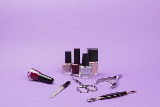 Los productos de cuidado esmaltes de uñas y accesorios para uñas. Accesorios de manicura. Fondo violeta
. - Foto, Imagen