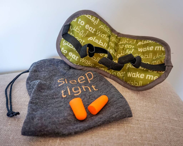 viajero preparándose para dormir en un avión preparando una máscara para dormir, tapones para los oídos para el vuelo
 - Foto, Imagen
