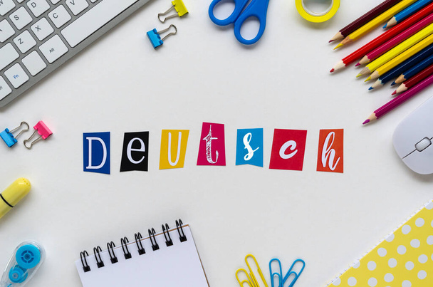 Slovo DEUTSCH vytvořené barevnými písmeny na bílém stole s klávesnicí a školní šablonou. Top view Naučte se nový jazyk doma během karantény COVID-19 - Fotografie, Obrázek