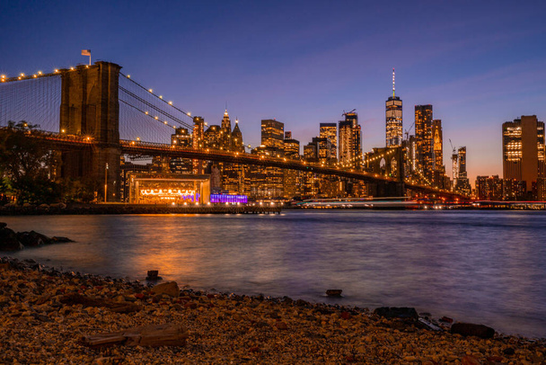 Brooklyn Köprüsü 'nün, Brooklyn Parkı' ndan Hudson Nehri 'nin diğer tarafındaki Manhattan manzaralı büyülü akşam günbatımı manzarası.. - Fotoğraf, Görsel