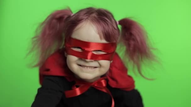 Funny child girl in costume and mask plays super hero. National superhero day - Footage, Video