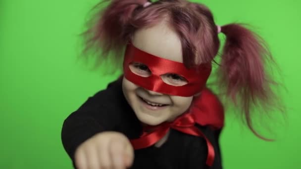 Grappig kind meisje in kostuum en masker speelt super held. Nationale superheldendag - Video