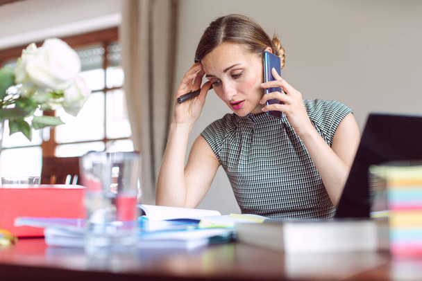 Geschäftsfrau, die in Krisenzeiten von zu Hause aus arbeitet, ist gestresst - Foto, Bild