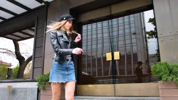 Französin, ein Mädchen im französischen Stil, läuft durch die Innenstadt, im kurzen Minirock, mit Handtasche, beugt sich, um ihre Schuhe zu richten, wirbelt um die Laternenmasten, lächelt - Filmmaterial, Video