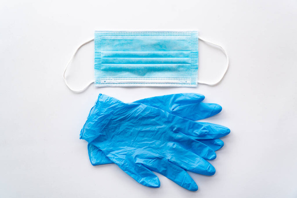 Коронавирус COVID-19 защитных субъектов. Одноразовые резиновые медицинские перчатки и маска на белом фоне
 - Фото, изображение