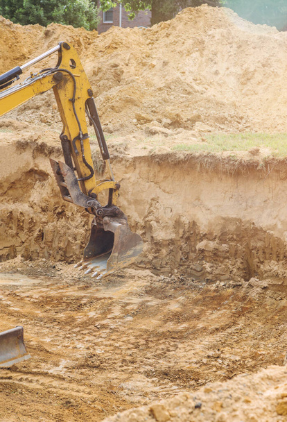 Cubo de trabajo de excavadora en movimiento para cimentación en obra en las obras de tierra
 - Foto, imagen