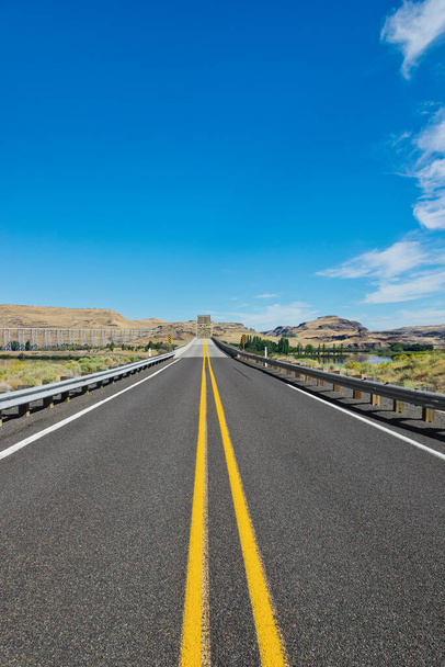 This two land road and dry climate, has a bridge seen in the distant background which crosses over Snake River in Eastern Washington State. - Photo, Image