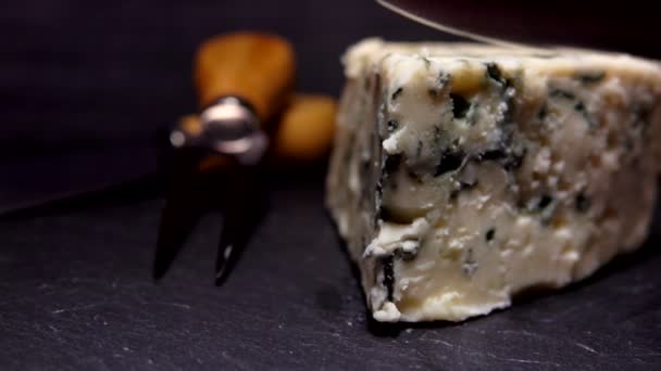 Super close-up of a knife cutting and lifting a piece of blue-mold cheese - Metraje, vídeo