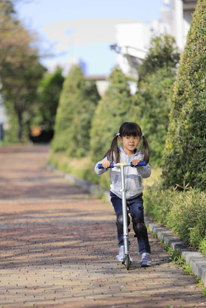 Japanese girl riding on a scooter (5 years old) - Photo, Image