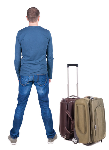 Back view of young man traveling with suitcase. - Photo, Image