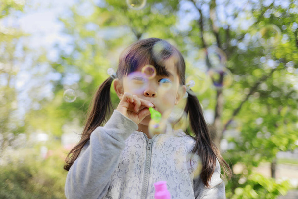 Japanese girl playing with bubble in the green (5 years old) - Foto, Imagem