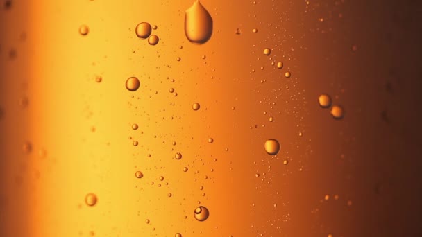 ビールボトルガラスの凝縮液滴のドロップフルHDクローズアップビデオ。黄色の背景に落ちてくる水滴 - 映像、動画