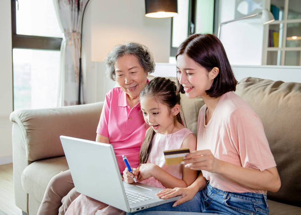 Feliz abuela con el niño y la hija divirtiéndose compras en línea en casa
  - Foto, imagen
