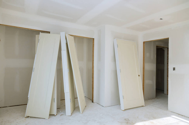Voorbereiding van binnenkastdeuren voor installatie in een bouwsector nieuwbouw - Foto, afbeelding